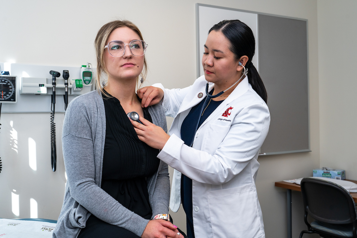 Nurse checking heart rate of a patient.