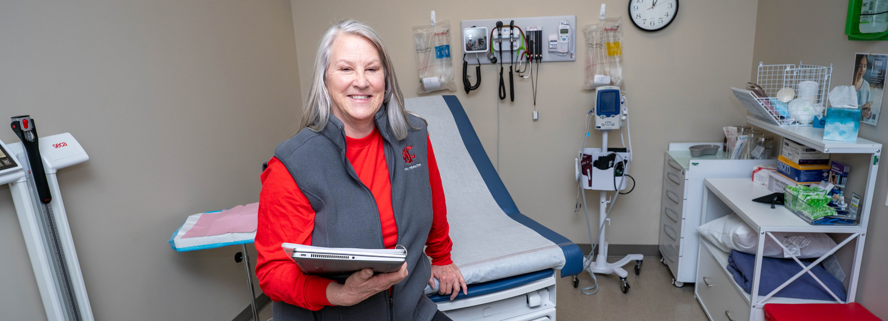Nurse smiling, holding a chart.