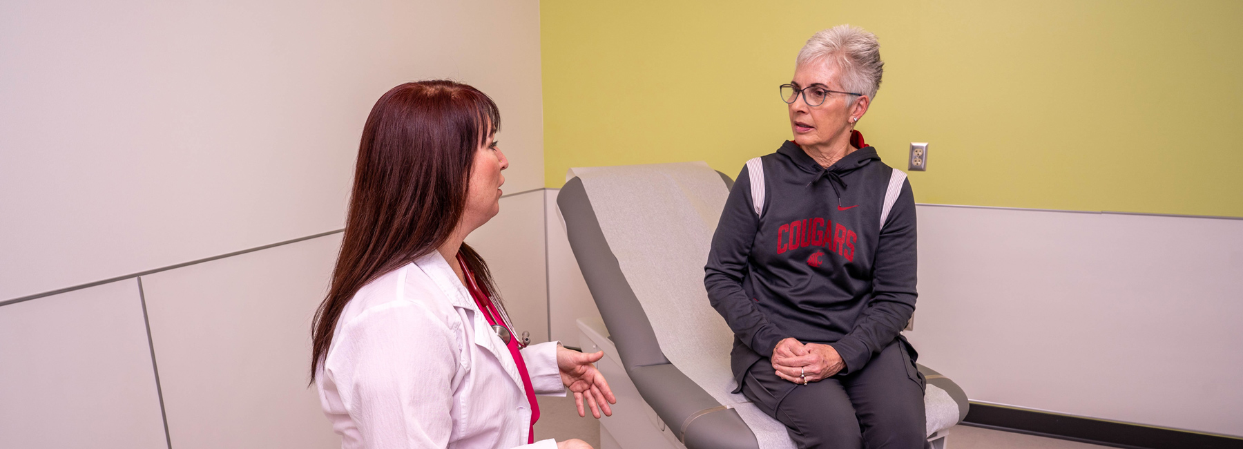 An elderly patient talking to a nurse about chronic pain.