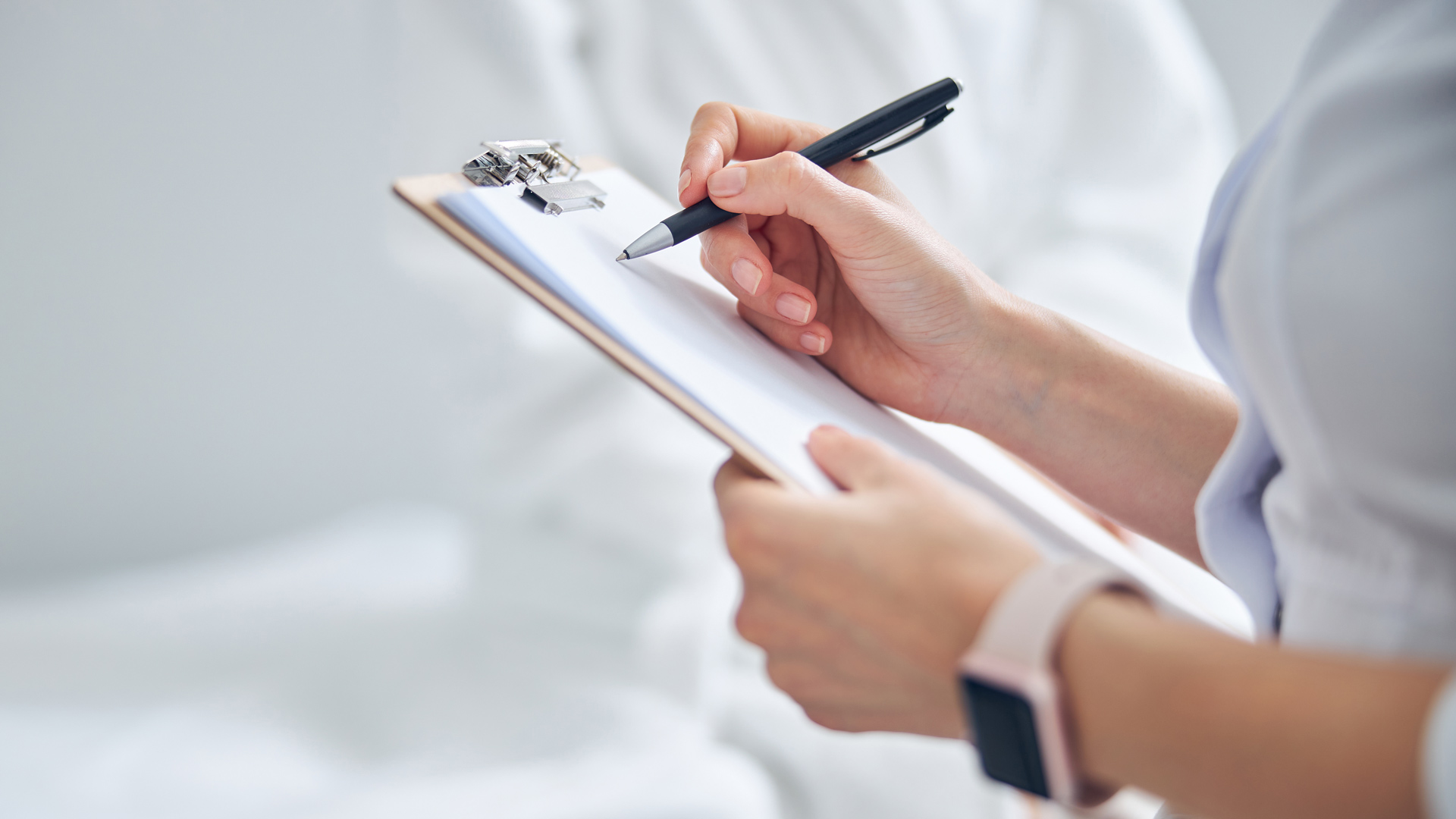 Close up of a hand writing on a chart.