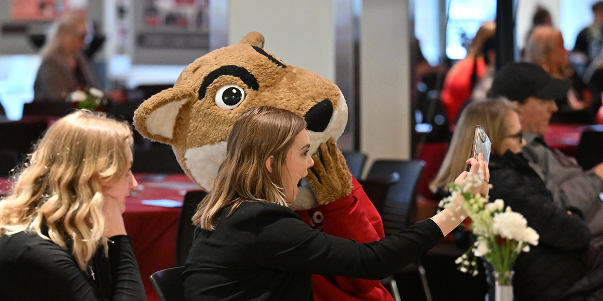 Student taking a picture with the WSU macot, Butch.