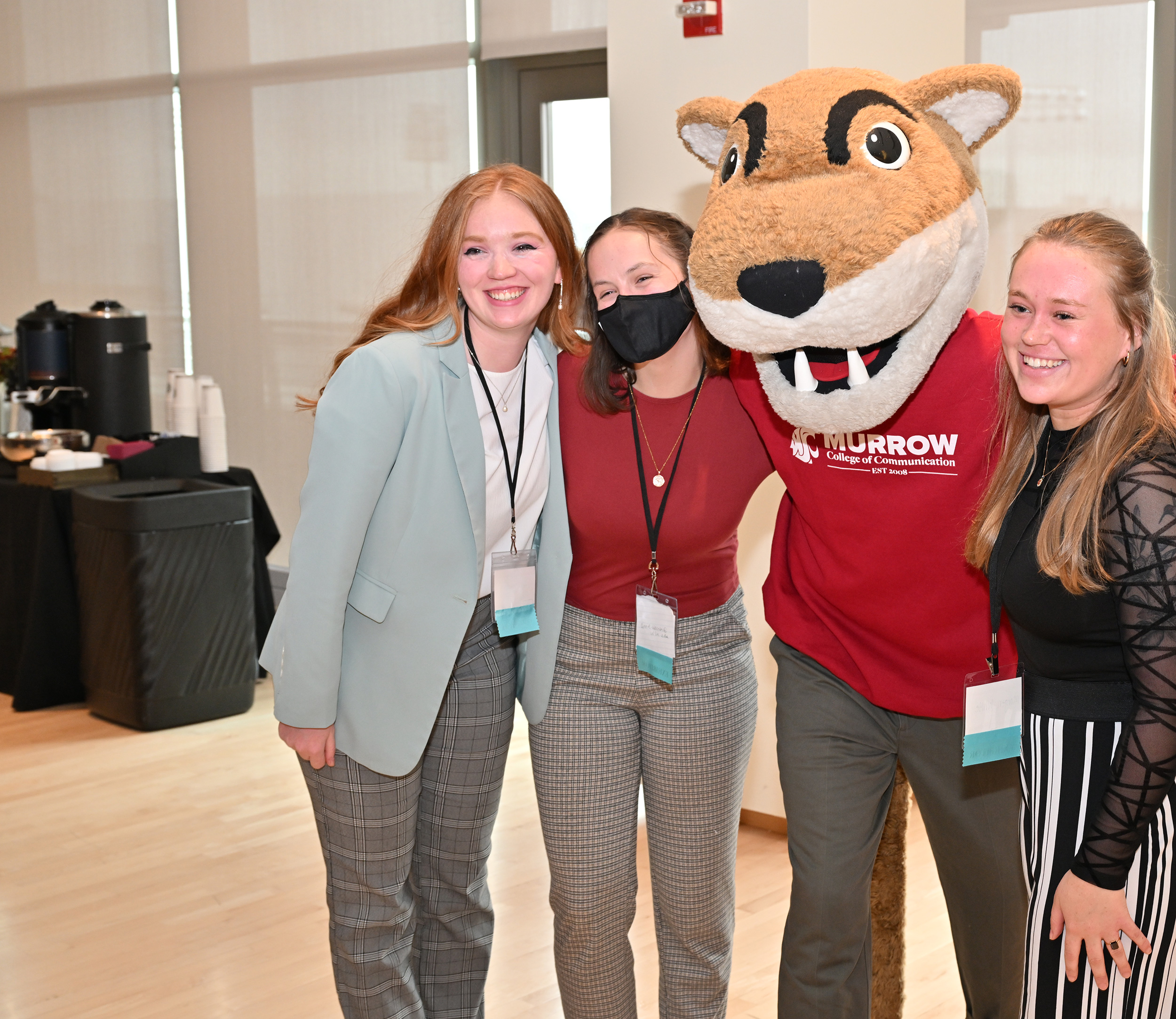 WSU Mascot, Butch, wearing a Murrow College of Education Sweatshirt, poses with three students