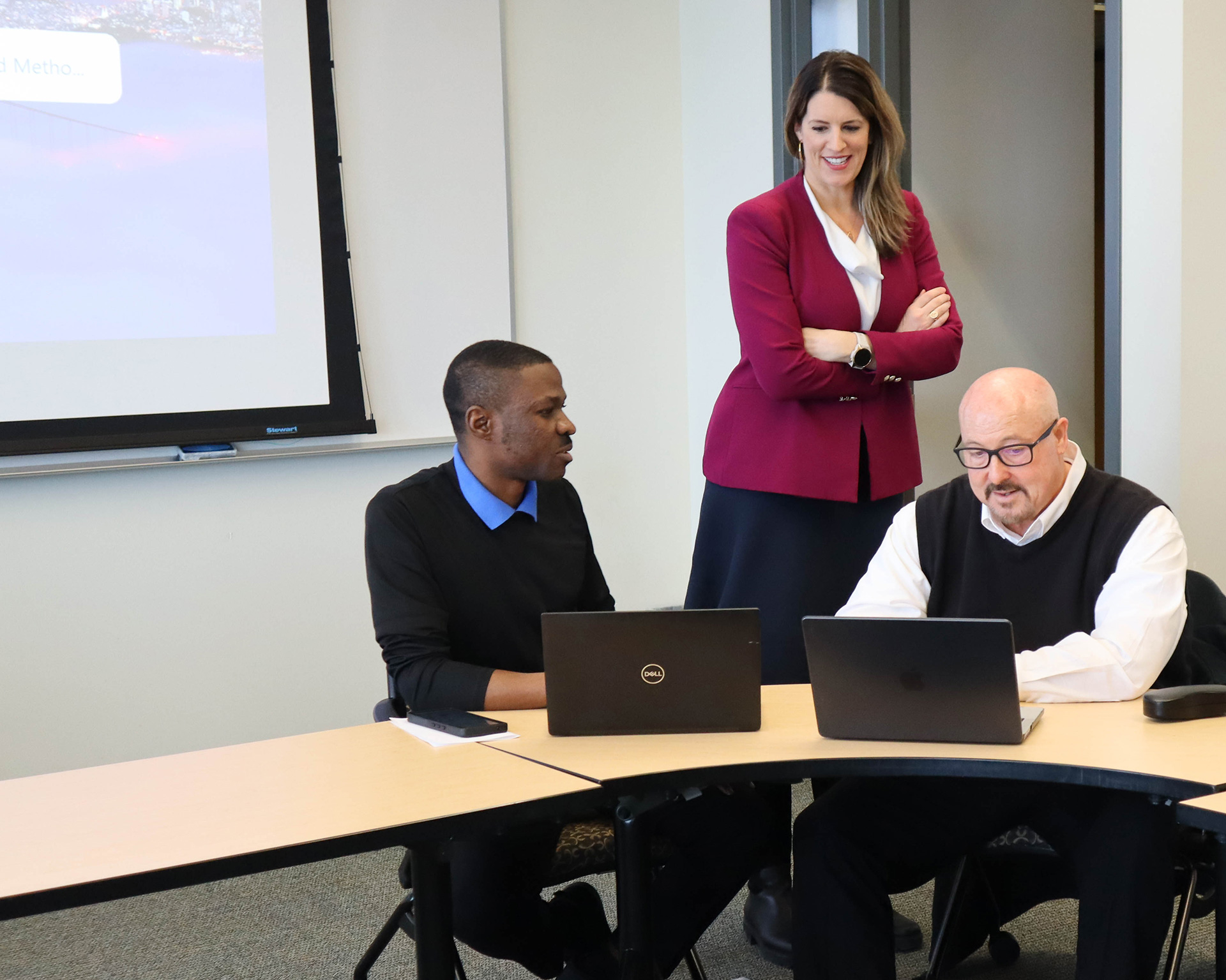 Instructor and two students on laptops