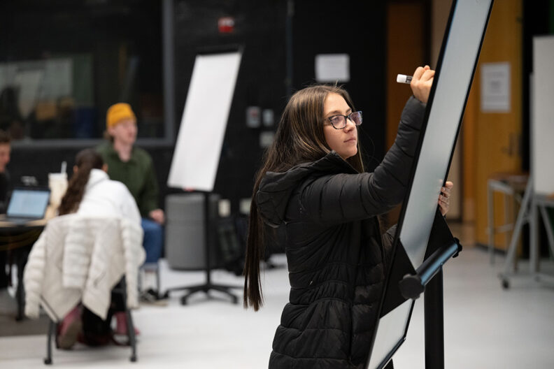 students writing on whiteboards