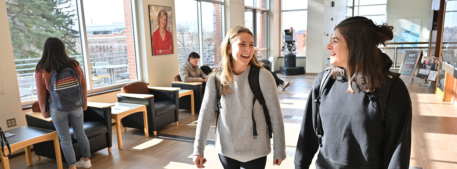 Students laughing and walking down a school hall