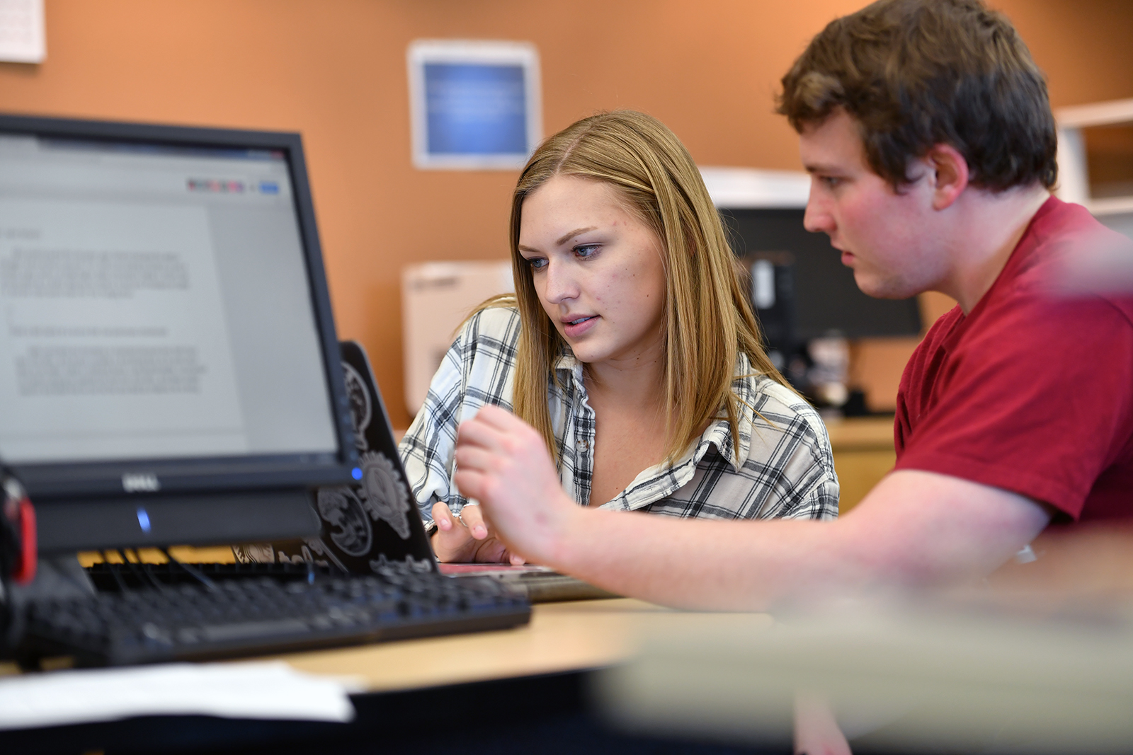 man and woman work at a computer together