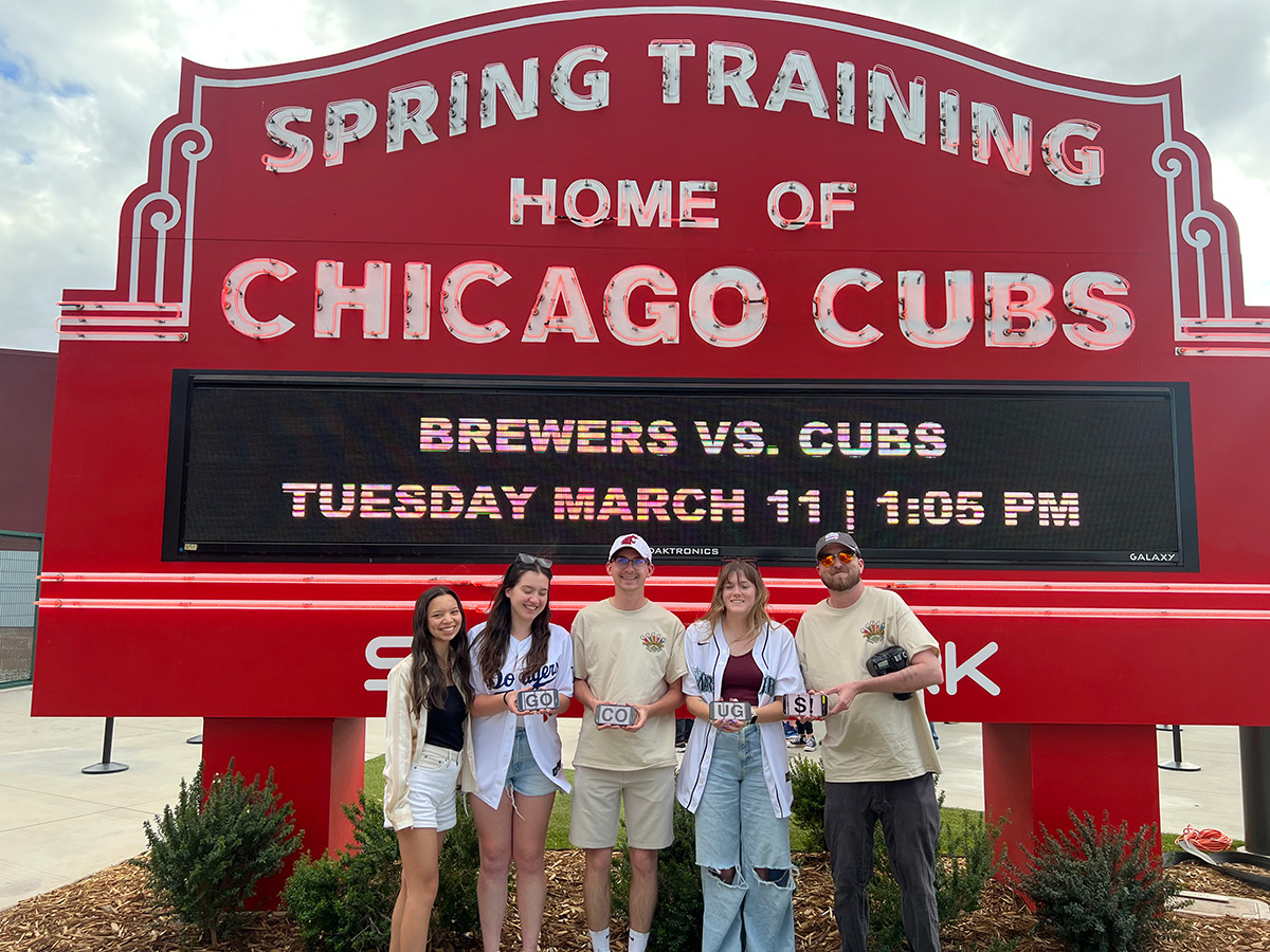 Murrow students stand in front of a red Spring Training Home of Chicago Cubs sign in Arizona