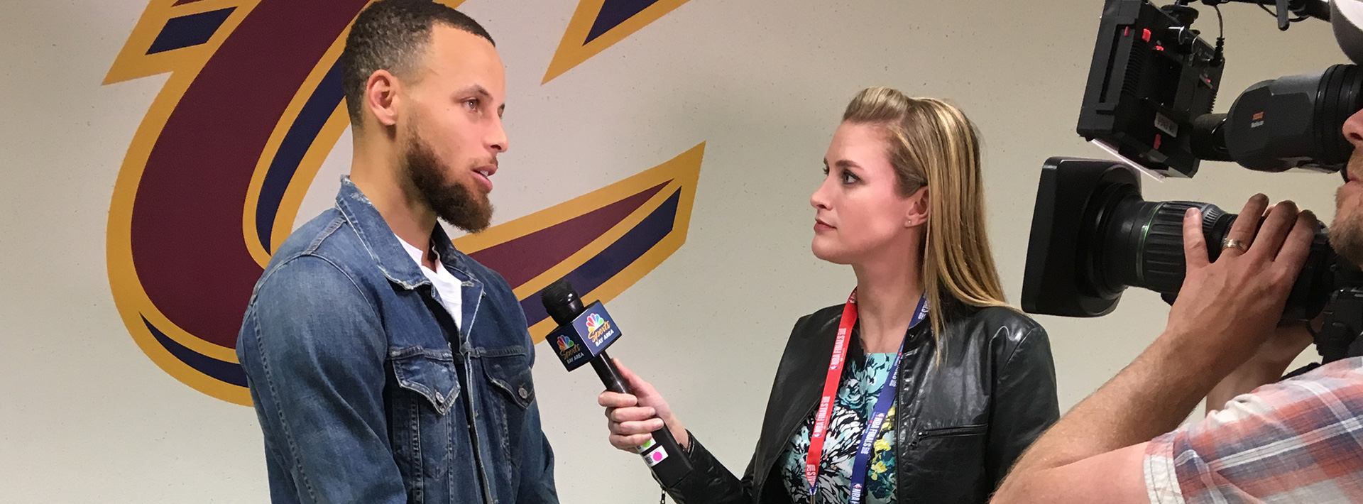 Videographer recording a female reporter interviewing a male athelete.