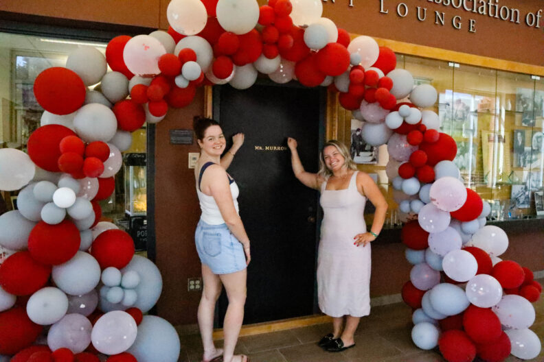 Two spring 2025 graduates knock on Murrow's door in celebration of Commencement. 