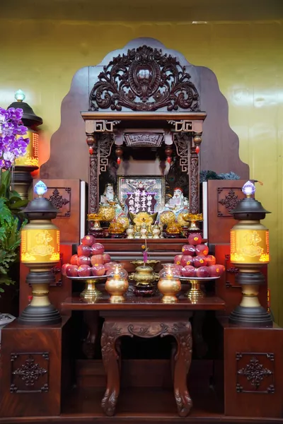Intricate shrine, dark wood base, showing two pyramid piles of apples.