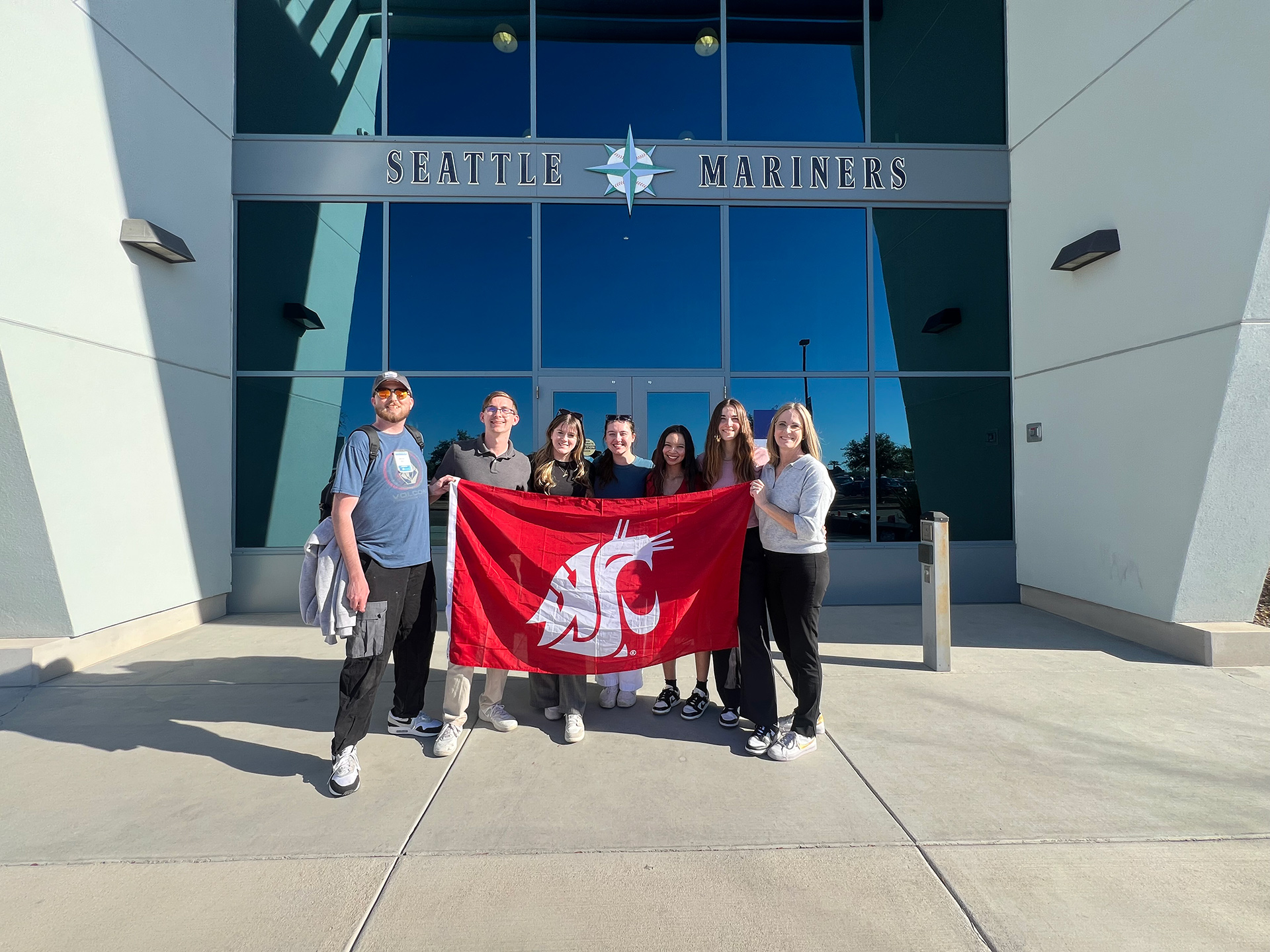 Students holding a WSU flag outside the Seattle Mariners building