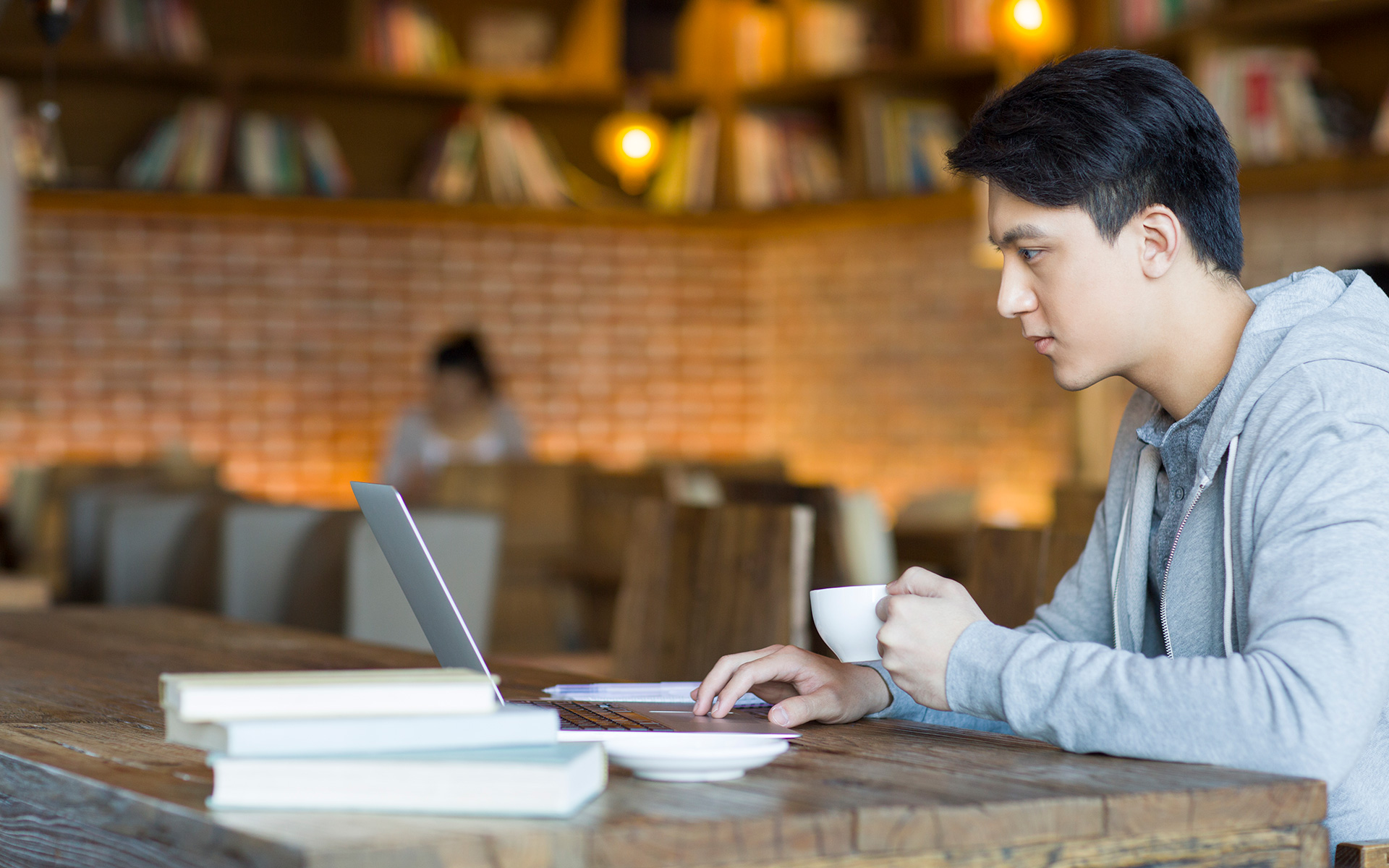 man studying on a laptop in a coffee shop
