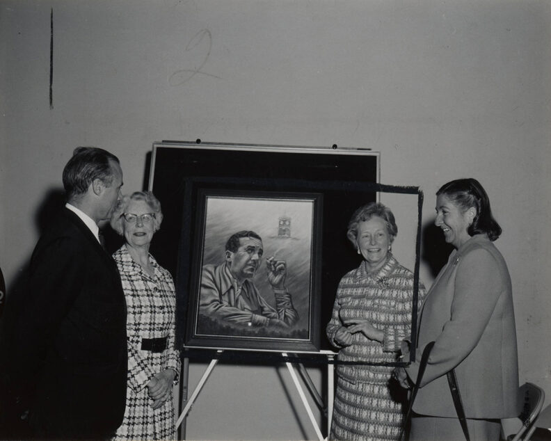 Henry T. Loomis, Frances Penrose Owen and Janet Murrow stand next to a picture of Edward R. Murrow.