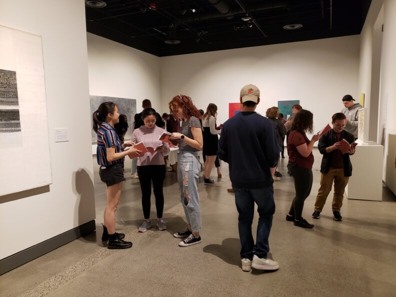 Students and visitors looking at books during a book release event.