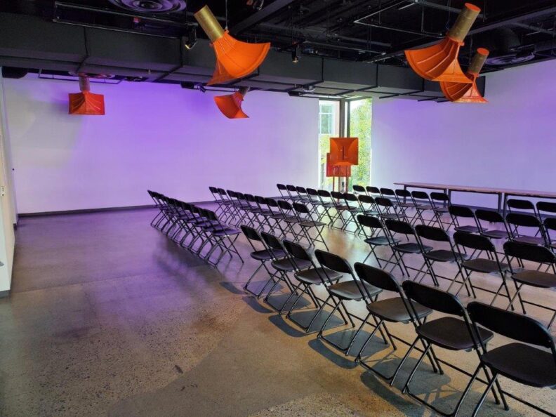 A group of empty chairs showing the space of the gallery.