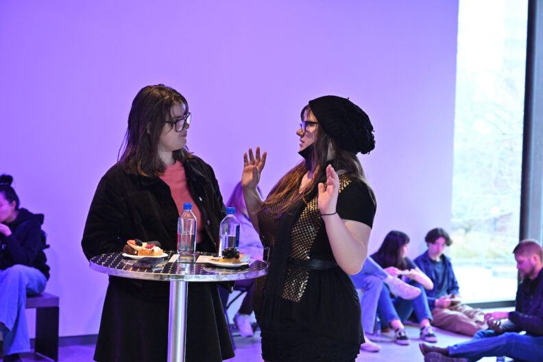 Two people chatting in the pavilion gallery.