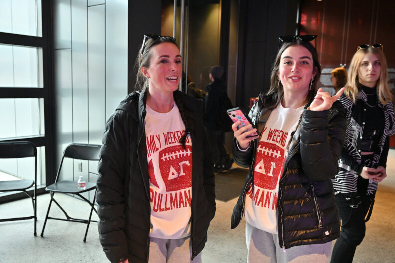 Two people in matching outfits chatting in the museum pavilion gallery.