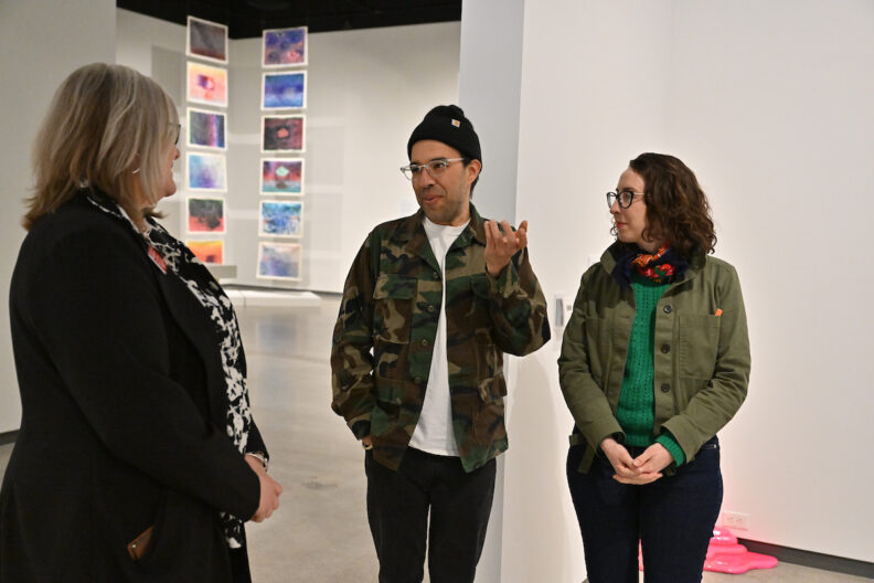 Juventino Aranda chats with two people in the museum gallery.