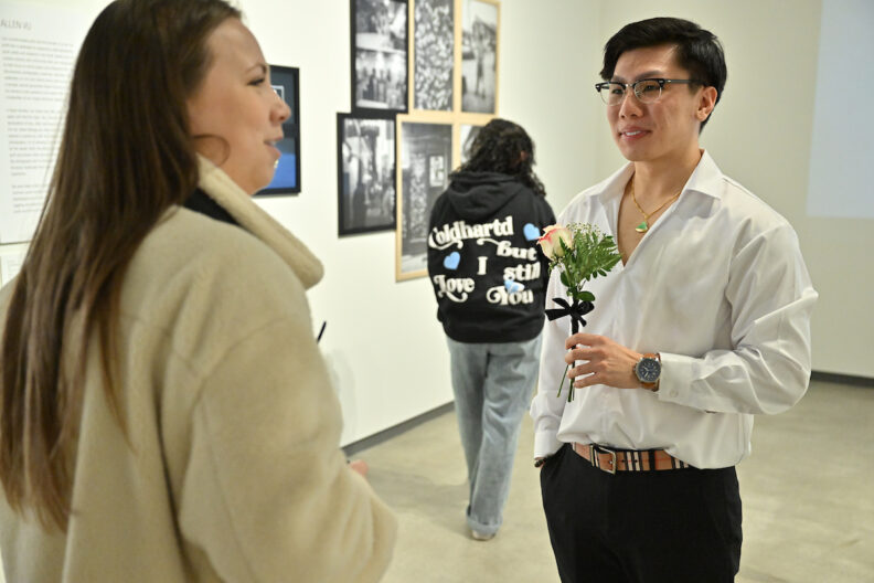 Allen Vu talking to a visitor in the museum gallery.
