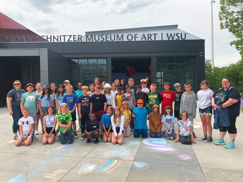 Sunnyside Elementary's fifth grade class gathered next to their chalk drawings on the ground in front of the WSU Jordan Schnitzer Museum of Art