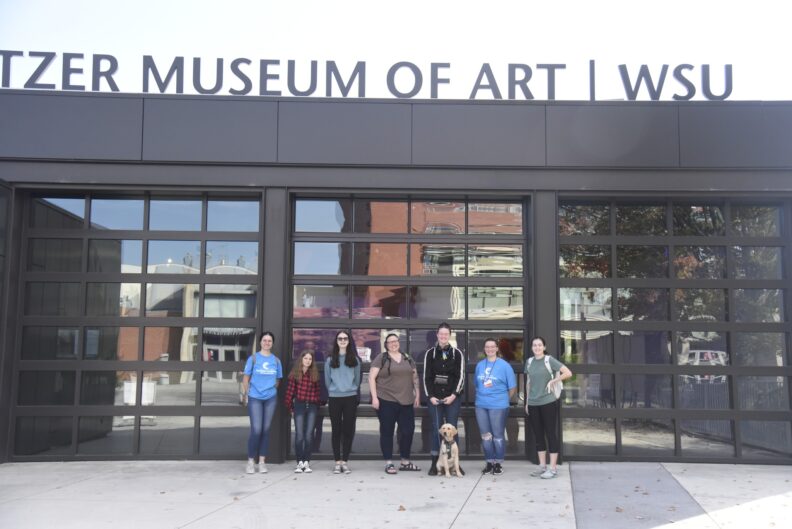 Girl scouts and Americorps volunteers stand in front of the WSU Museum of Art.