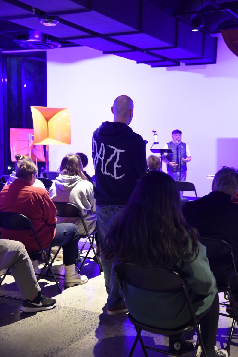 A crowd of people gather to listen to Sam Roxas-Chua speak.