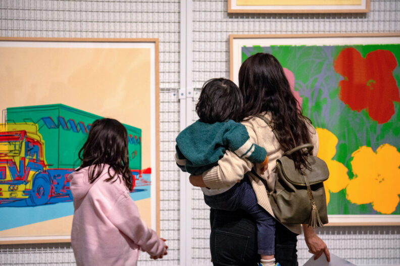 A family observes colorful art.