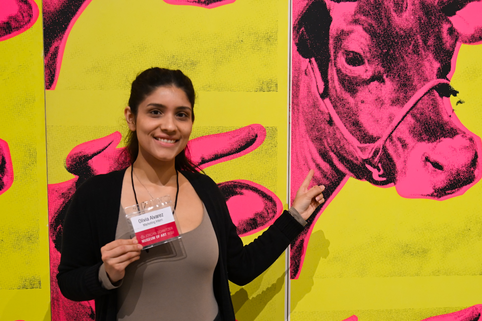 A photo of a woman in front of a colorful print of cows
