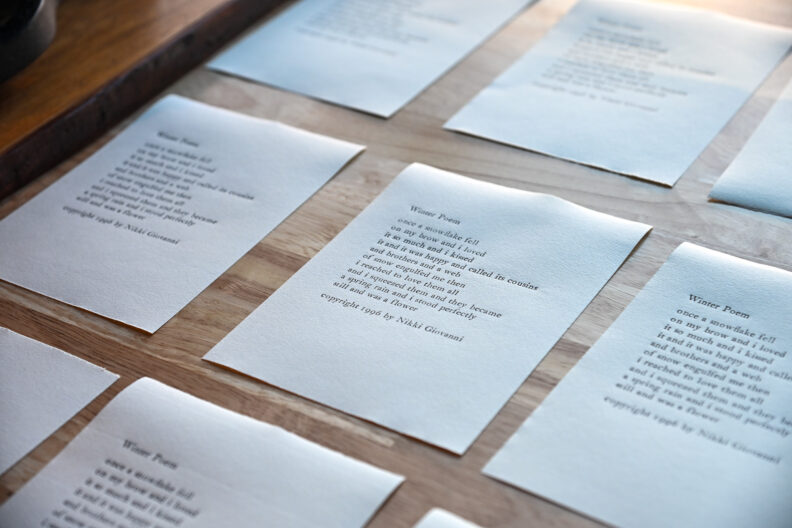 Sheets of paper with words for Writers Give Voice: Reading and Open Mic program in the Pavilion Gallery 01/21/25