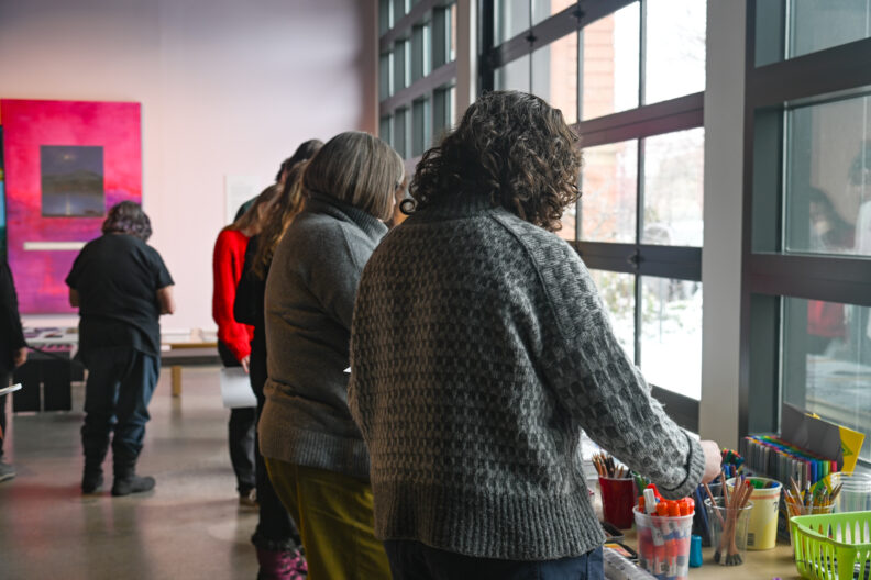 Image of participants standing in line to get supplies to begin making love letter zines