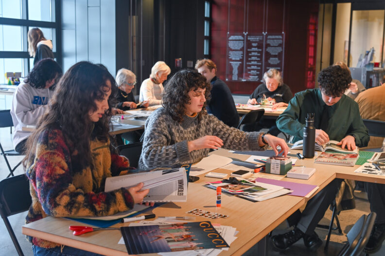 Image of people at tables with art supplies making making love letter zines