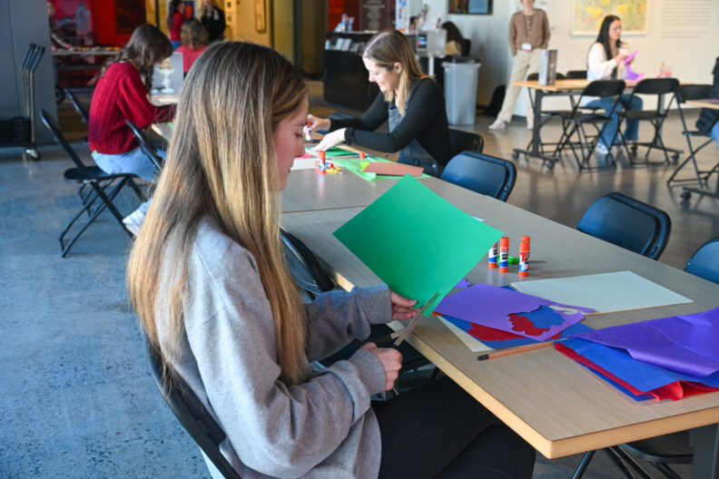 Image of tables with people using art supplies to create collages