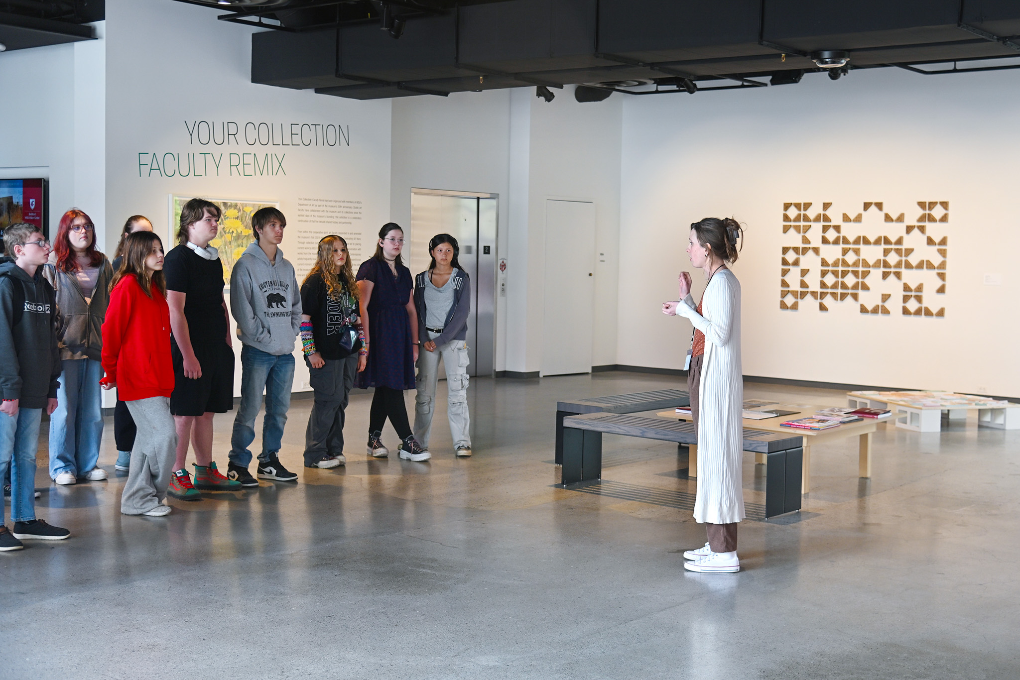 A museum staff member gives a tour to a group of middle schoolers.