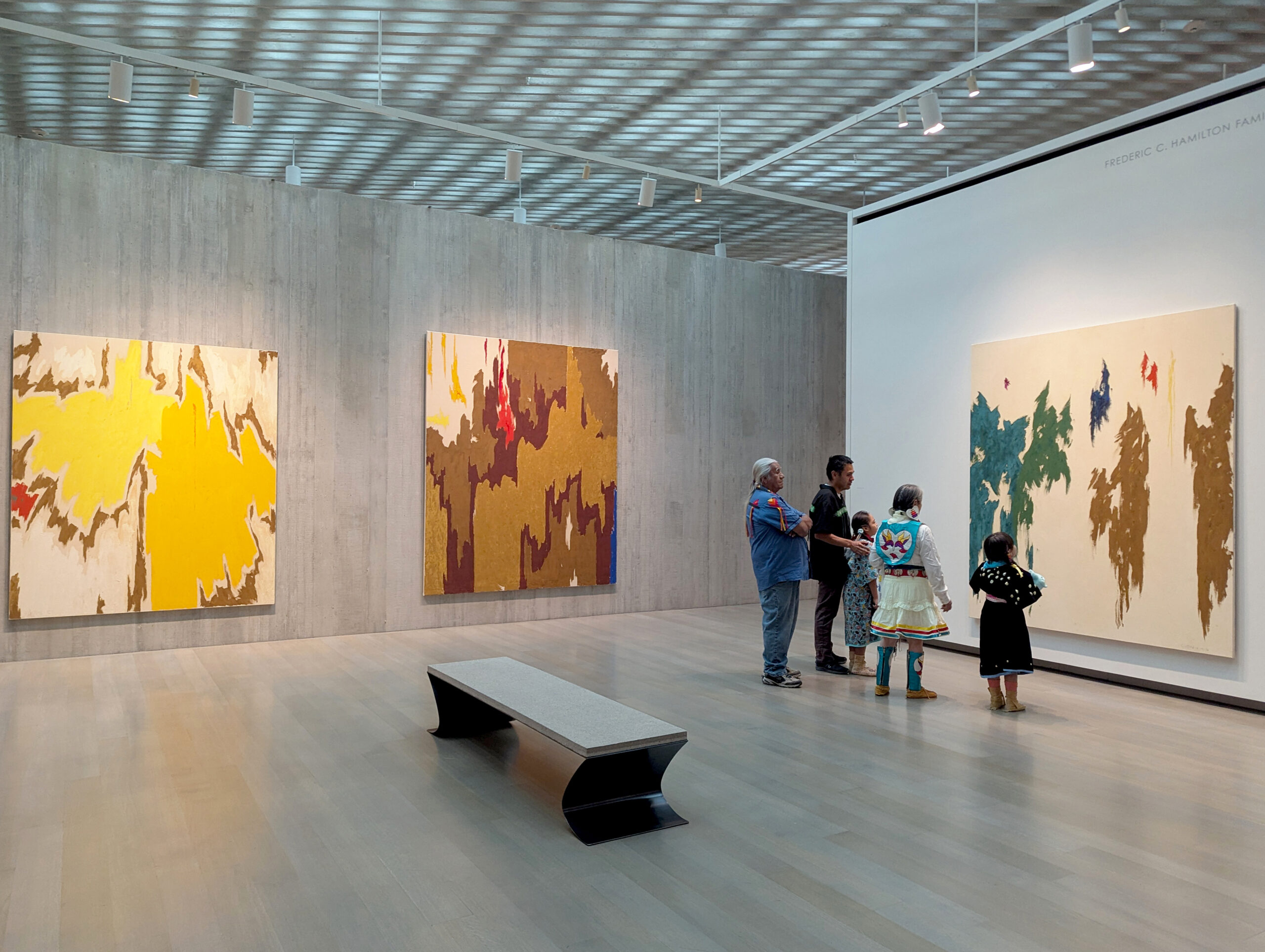 People in a gallery observing abstract paintings.
