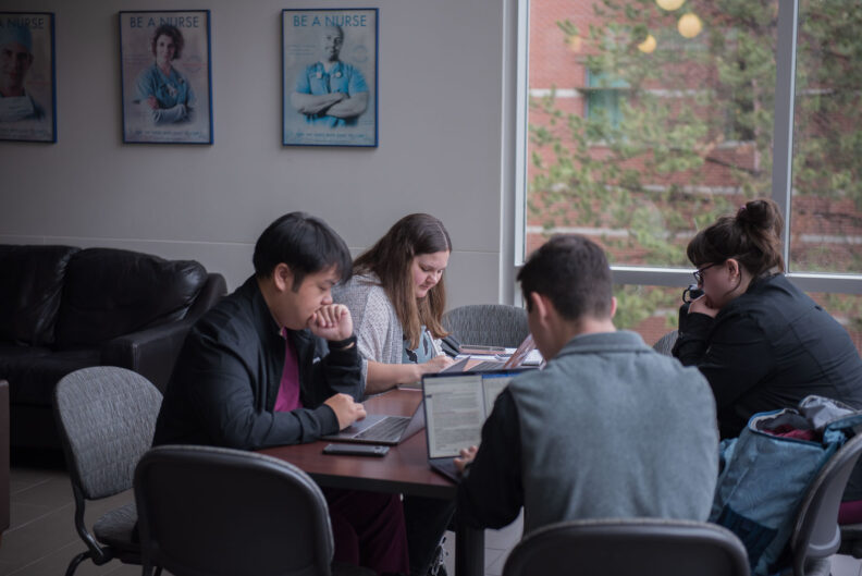 Nursing students studying at a table.