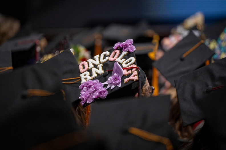 Nursing student's mortar board decoration that reads "Oncology RN". 