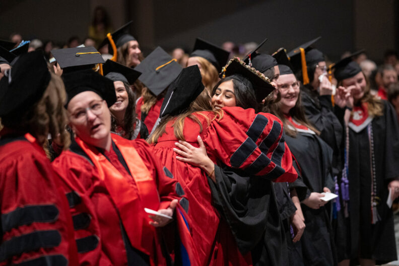 Graduating nursing students hug each other to give thanks for support throughout their time as WSU College of Nursing students.