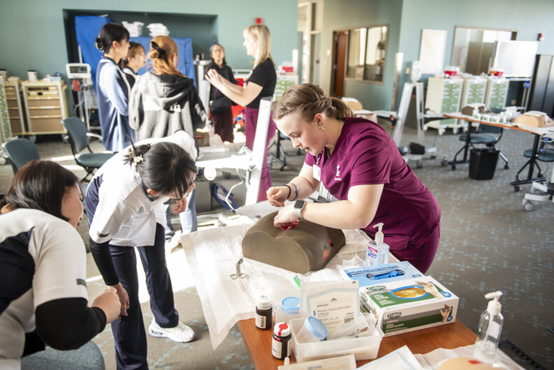 Greta G. '25 demonstrates wound care on a task trainer. 