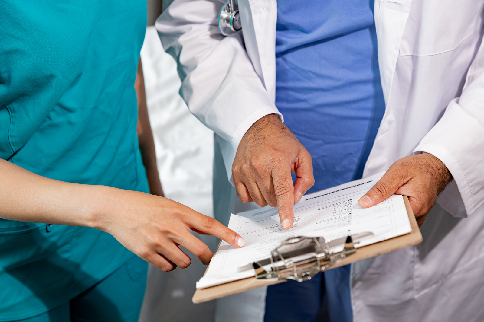 Doctor and nurse reviewing a chart on a clipboard.