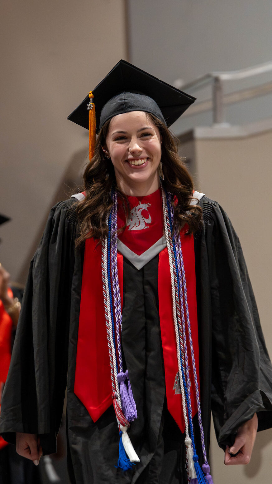 Nursing graduate walking toward the stage during the Fall 2025 Graduation and Pinning Ceremony.