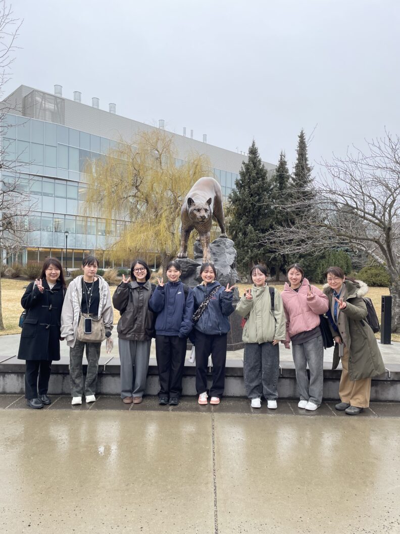 Iwate students posing with the bronze cougar statue on the WSU Spokane campus.