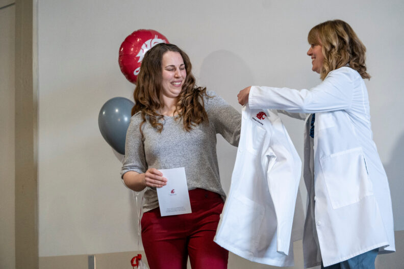 Audra Podruzny receiving her white coat from Dr. Sarah Fincham at the 2025 DNP white coat ceremony in Spokane. Photo Cori Kogan.
