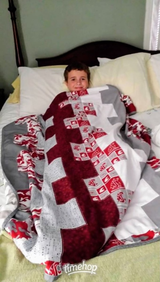 A staff member's son, wrapped up in a WSU Cougar themed quilt made by Sue Perkins. Photo: H. Belcher