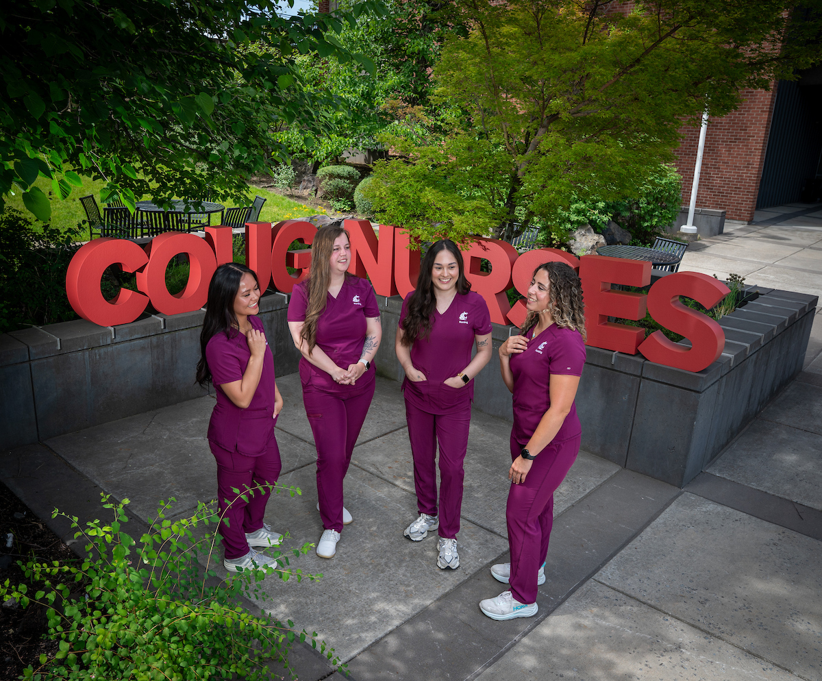Nursing students standing in the healing garden with COUG NURSE letter forms behind them.