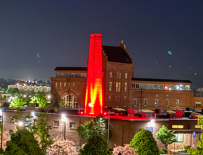 Night time view of the WSU Spokane CCRS building's smokestack, lit up with red lights for Nurses Week 2026. Photo: Brad Schwartz, WSU College of Nursing.
