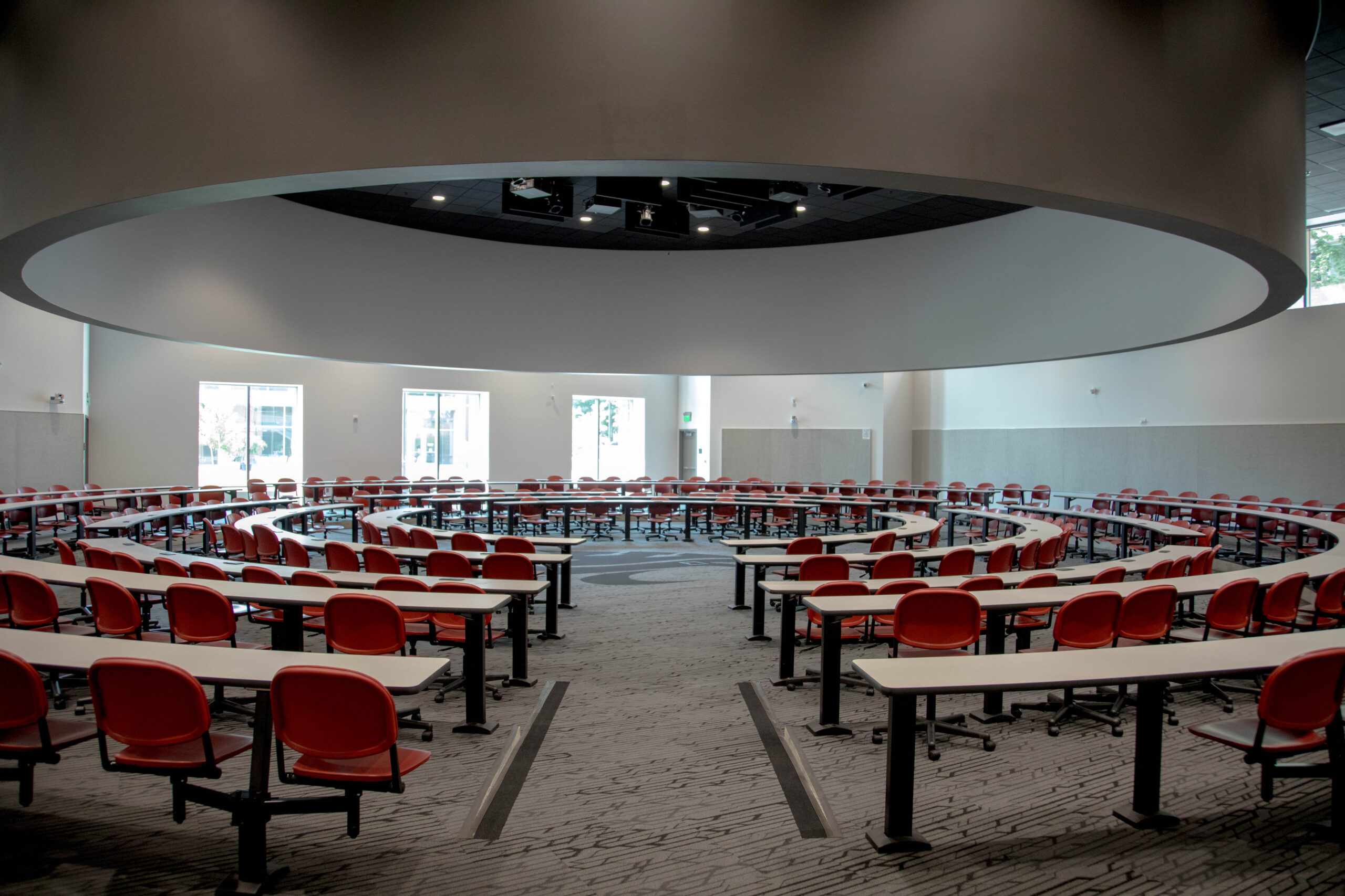 Empty seats in the well-lit, high-tech Spark G45 classroom. The seating is arranged in a circular configuration designed for the lecturer to stand in the center.