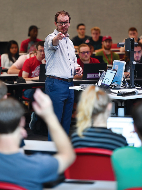 A professor teaching in the Spark building calls on a student during class.