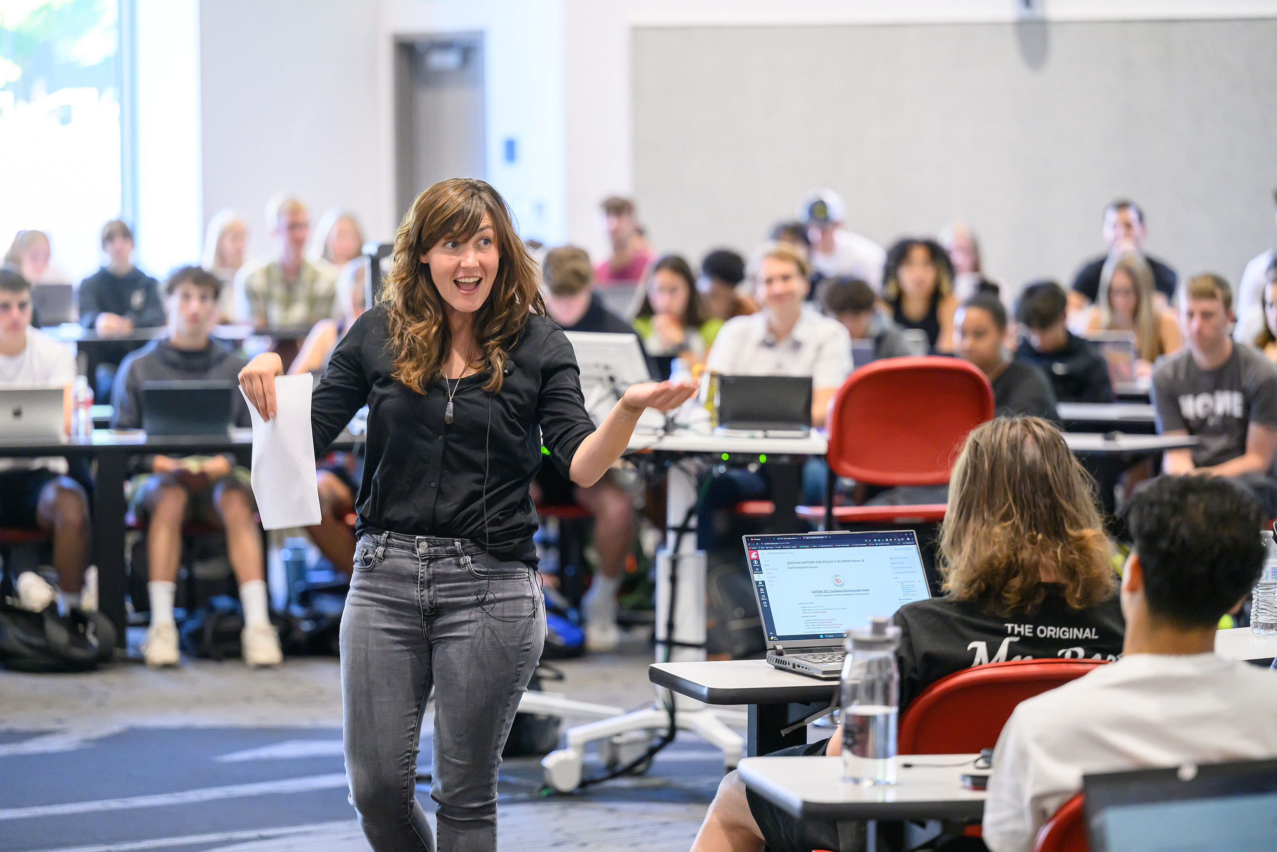 WSU professor teaches a course from the center of a classroom in the Spark building as students listen from wrap-around seating.