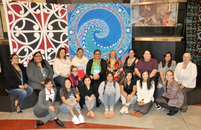 Group seated in front of tapestries