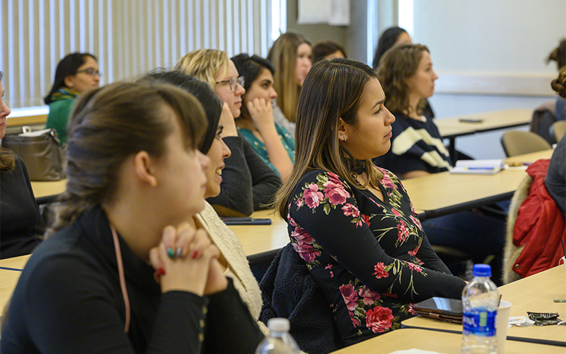 Transfer students sit in a classroom and listen to a workshop speaker.